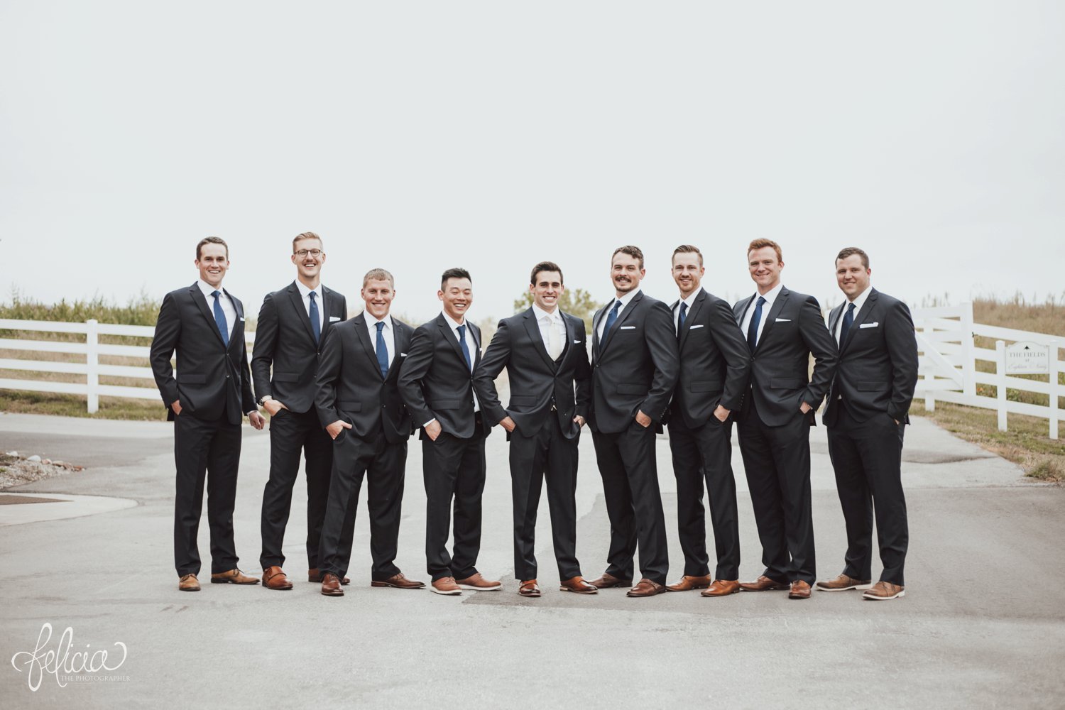 images by feliciathephotographer.com | destination wedding photographer | kansas city | eighteen ninety | classic | groomsmen portraits | walking | candid | cream tie | navy suit | royal blue | J. H. & sons clothier | brown leather shoes | country side | white picket fence | 