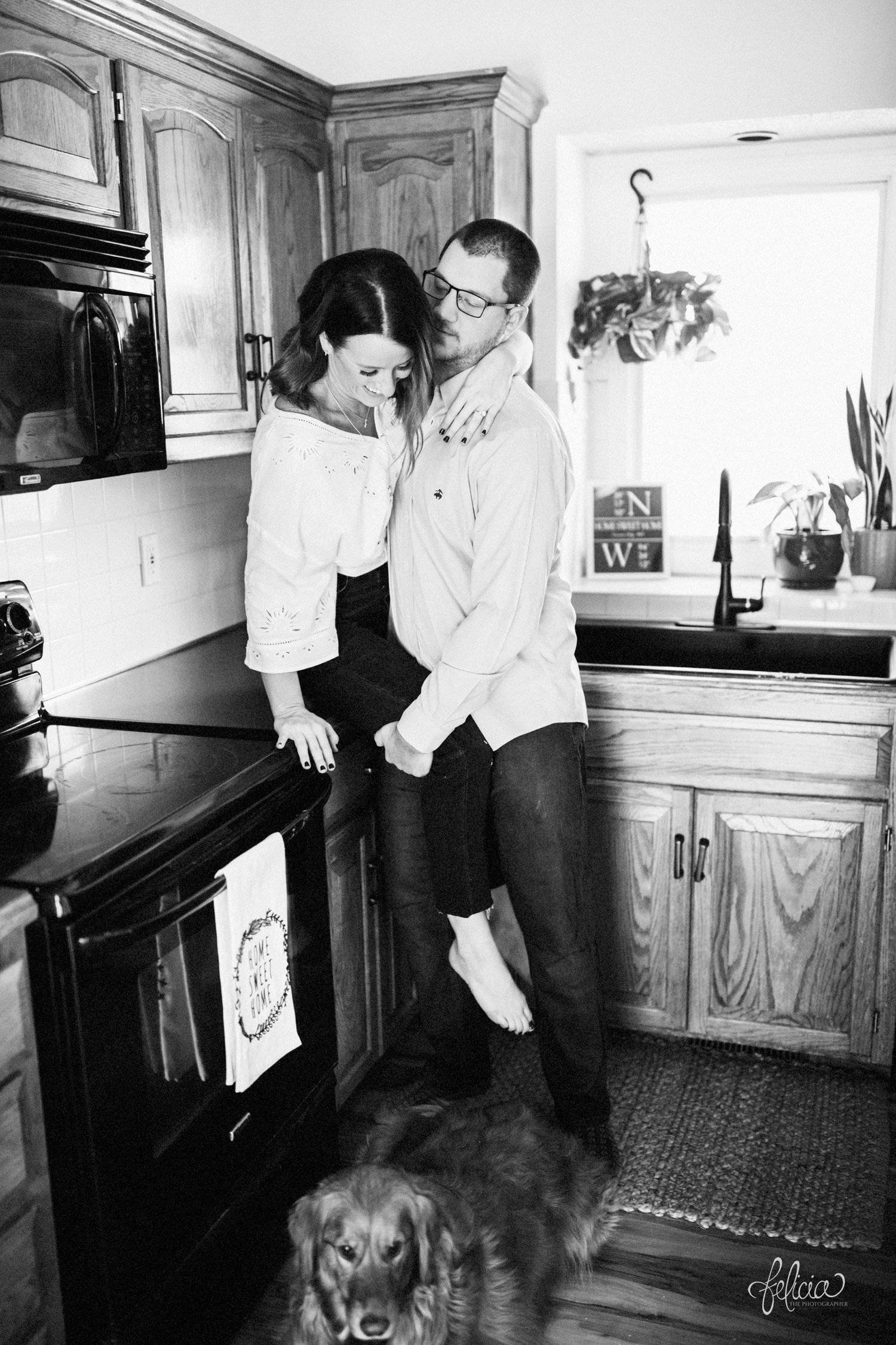 images by feliciathephotographer.com | destination photographer | engagement session | in home | lifestyle | kansas city | kitchen | sitting on the counter | black and white | romantic | love | natural light | joy | golden retriever | 