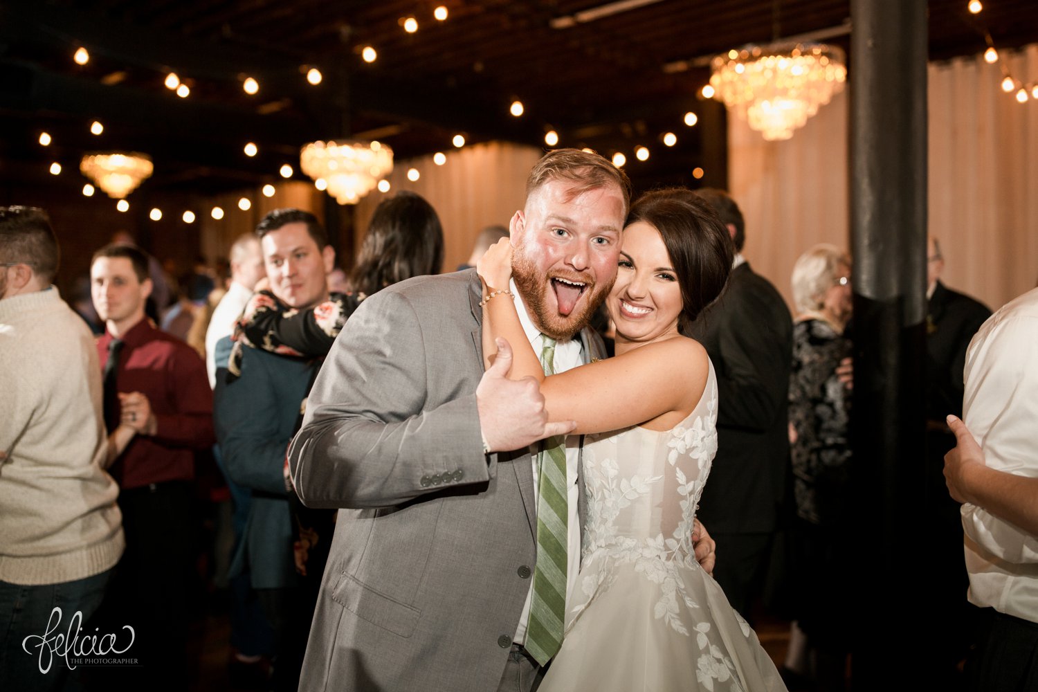 images by feliciathephotographer.com | magnolia venue | urban garden wedding | photographer | kansas city missouri | something white bridal boutique | the groomsman suit | grey and green | silly | tongue out | chandelier | hanging lights | dance floor | 