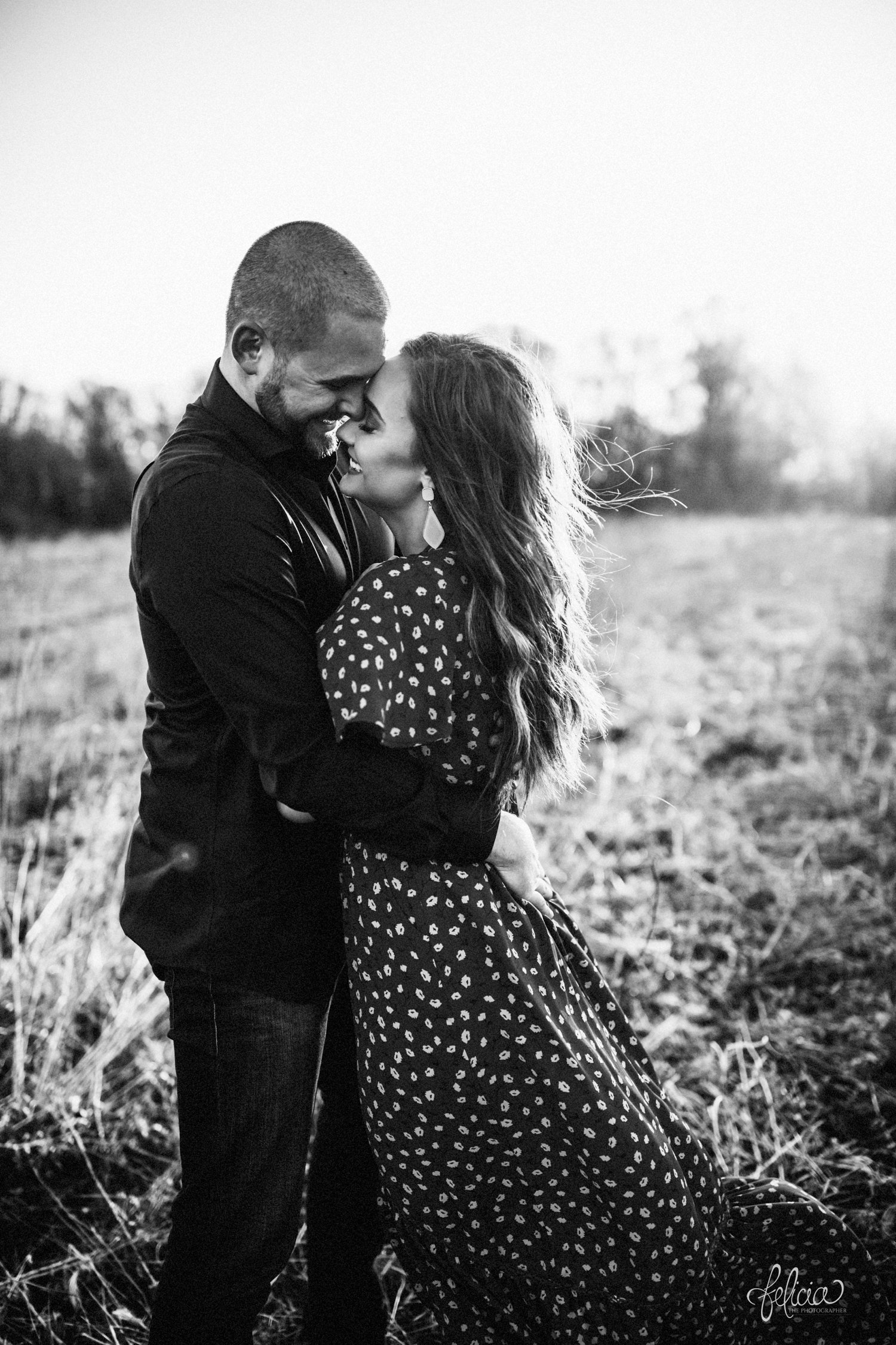 images by feliciathephotographer.com | Burr Oak Woods | engagement photos | wedding photographer | engagement photographer | field | sunrise | hugging | posed | posing | black and white | b&w | posed | posing | smiling | laughter | hug | hugging | floral dress | jeans | 