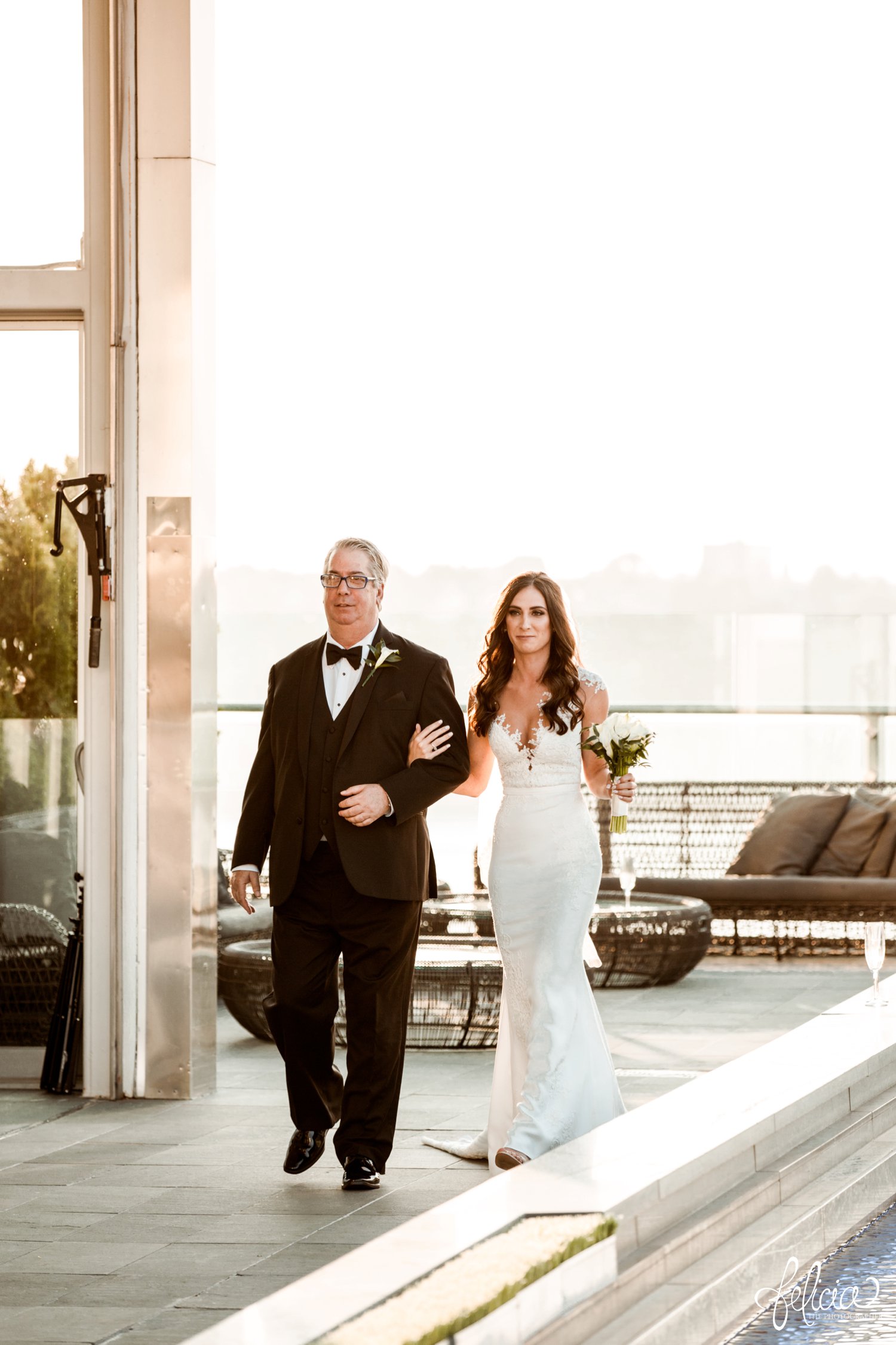 images by feliciathephotographer.com | destination wedding photographer | new york city | ceremony | rooftop | skyline | urban | romantic | classic | walking down the aisle | father of the bride | long white gown | lace detailed neckline | white flowers | golden hour | 